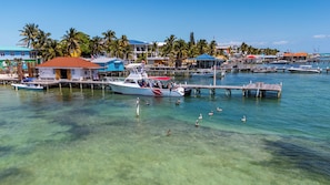A marina with boats docked, clear water, and buildings with red roofs. - Sunset Beach Resort (San Pedro)