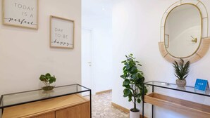 A modern bathroom with a glass vanity, a round mirror with a gold frame, and two framed motivational quotes on the wall. - Sweett | Fontana - Two Bedroom Apartment, Sleeps 5 (Milano)