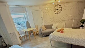 A cozy bedroom with a bed, a chair, and a small table.