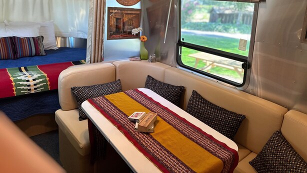 A cozy interior with a sofa, a small table, and a window with a view of a garden.