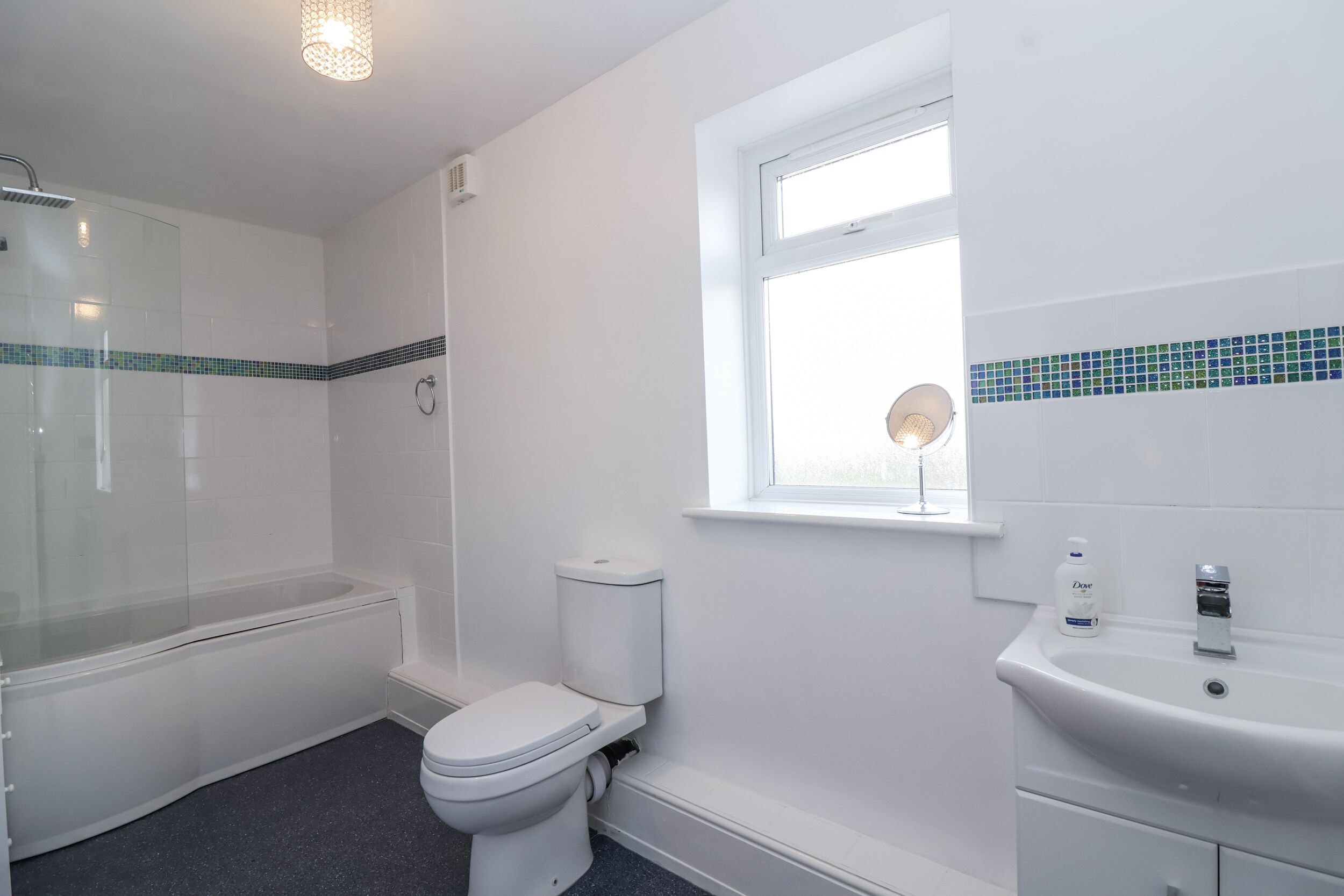 A bathroom with a bathtub, toilet, and sink.