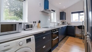 Une cuisine moderne équipée d’un lave-linge, d’un four à micro-ondes, d’un grille-pain et d’un four.