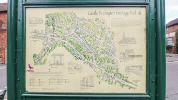 Señal de bienvenida para la ruta del patrimonio de Castle Donington, patrocinada por el Aeropuerto de East Midlands, que muestra un mapa de la ruta con puntos de referencia como Crown House y la iglesia de St Edwards.