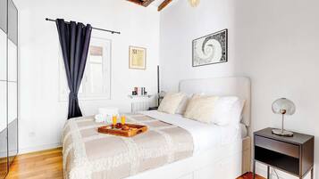 Een moderne slaapkamer met een bed, nachtkastje en een klein tafeltje.