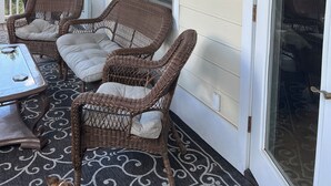 A covered porch with wicker furniture, a table, and a lantern. - Beautiful townhome in the village of Banner elk It doesn’t get better than this. (Banner Elk)