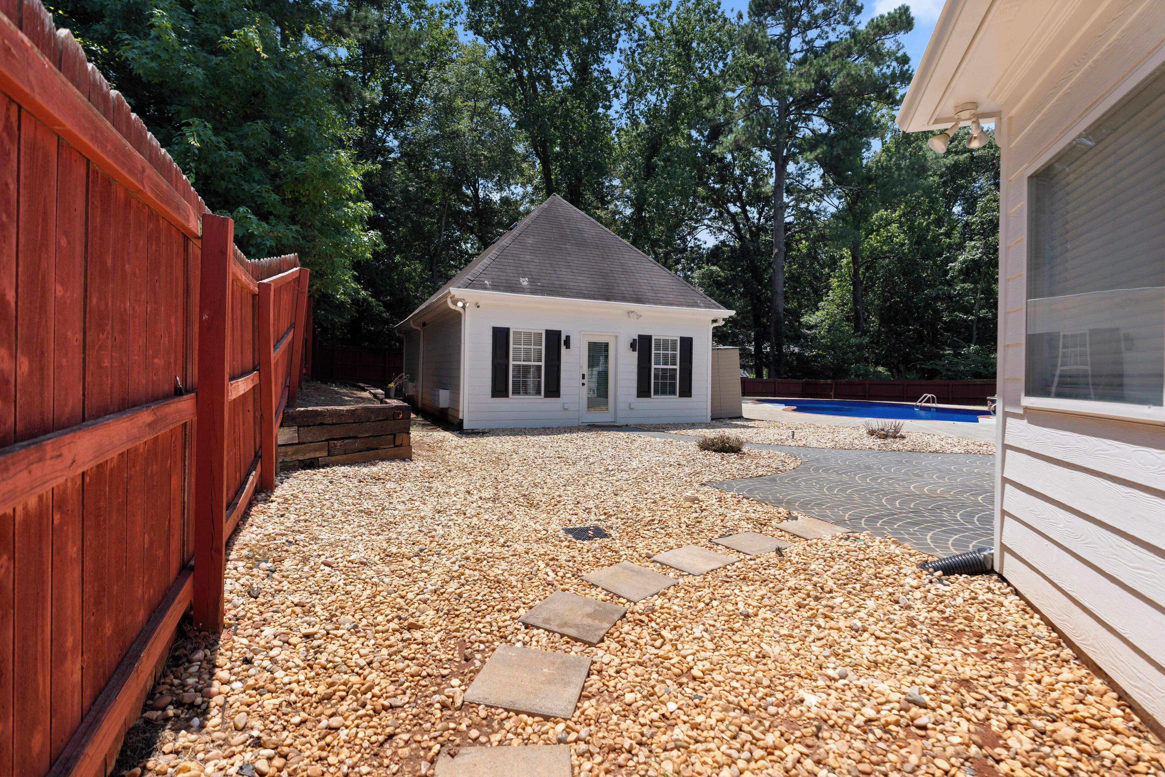 A house with a gravel driveway and a wooden fence.