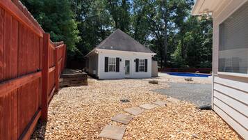 A house with a gravel driveway and a wooden fence.