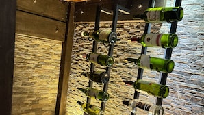 A wine rack with various bottles against a stone wall. - Casa Campestre Forest House - Unique Relaxation in Salento, Quindío (Salento)
