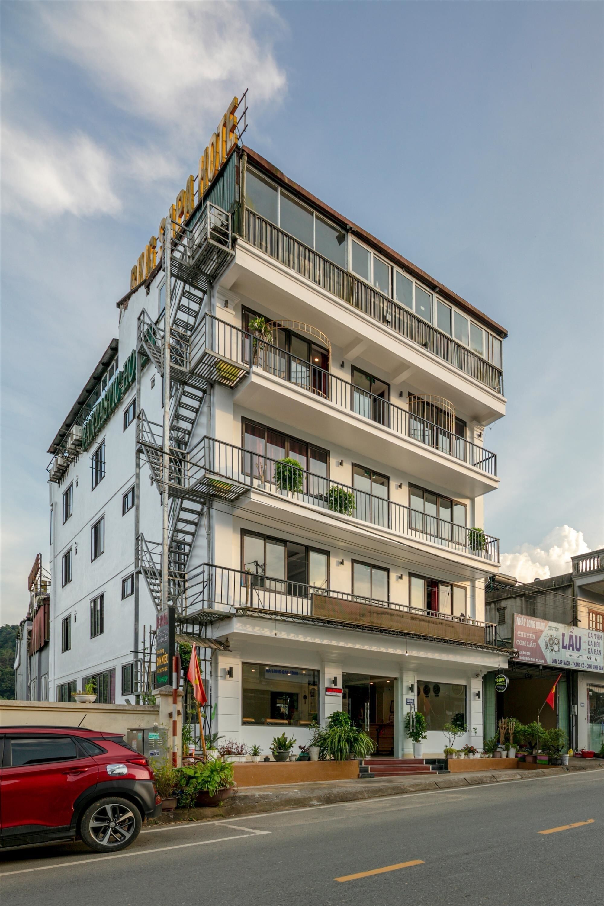 A multi-story hotel with balconies, a fire escape, and a storefront with signage.