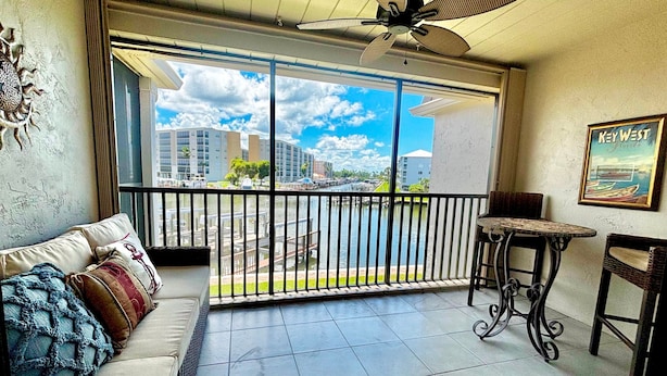 Un balcón con vistas a un puerto deportivo, un sofá, una mesita y una silla.