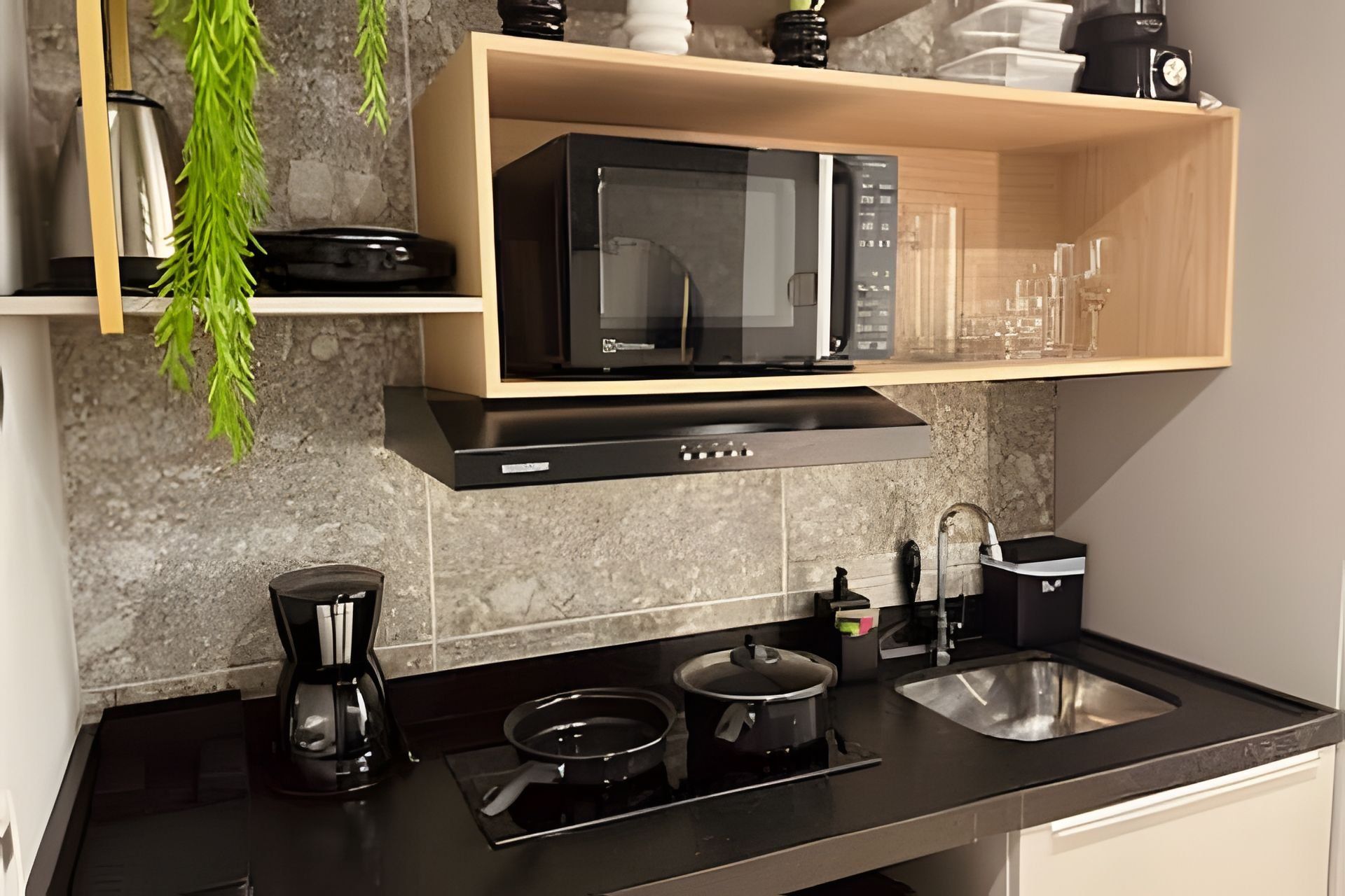 Una cocina moderna con microondas, cafetera, estufa y lavaplatos.