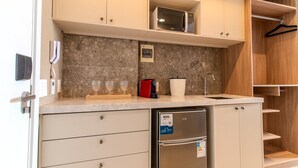 A compact kitchen with a microwave, a coffee machine, a refrigerator, and a sink. - Setai Yach (Joao Pessoa)