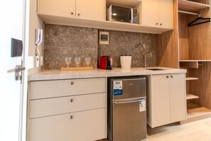 A compact kitchen with a microwave, a coffee machine, a refrigerator, and a sink. - Setai Yach (Joao Pessoa)