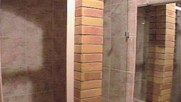 Un baño con cabina de ducha de vidrio, lavamanos y espejo.