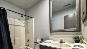 Un baño con bañera, inodoro, lavabo y espejo.