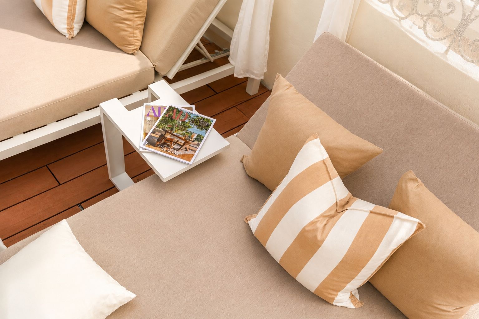 A cozy seating area with a sofa, cushions, and a small table with a magazine.