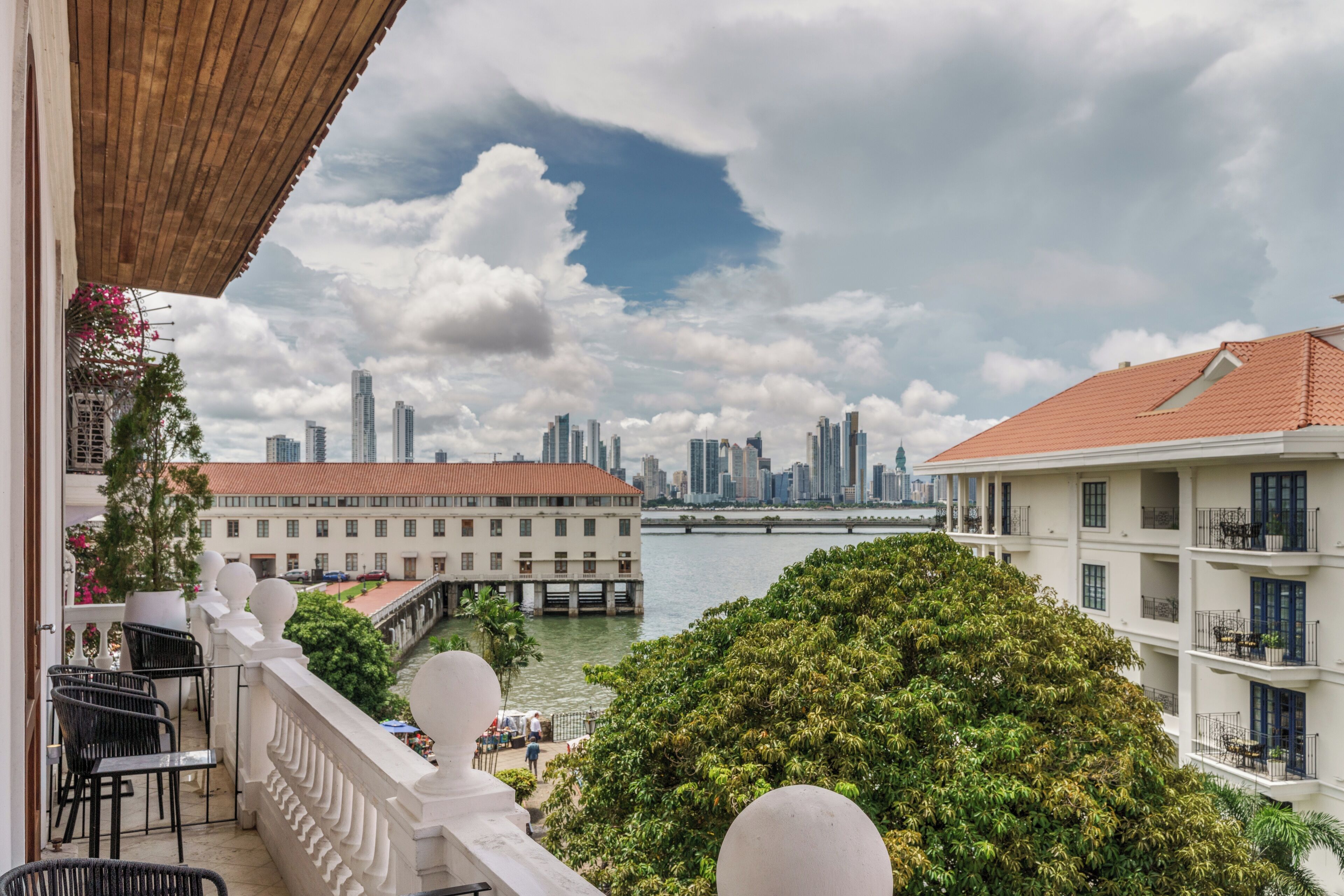 A balcony with a view of a city skyline, a river, and a bridge.