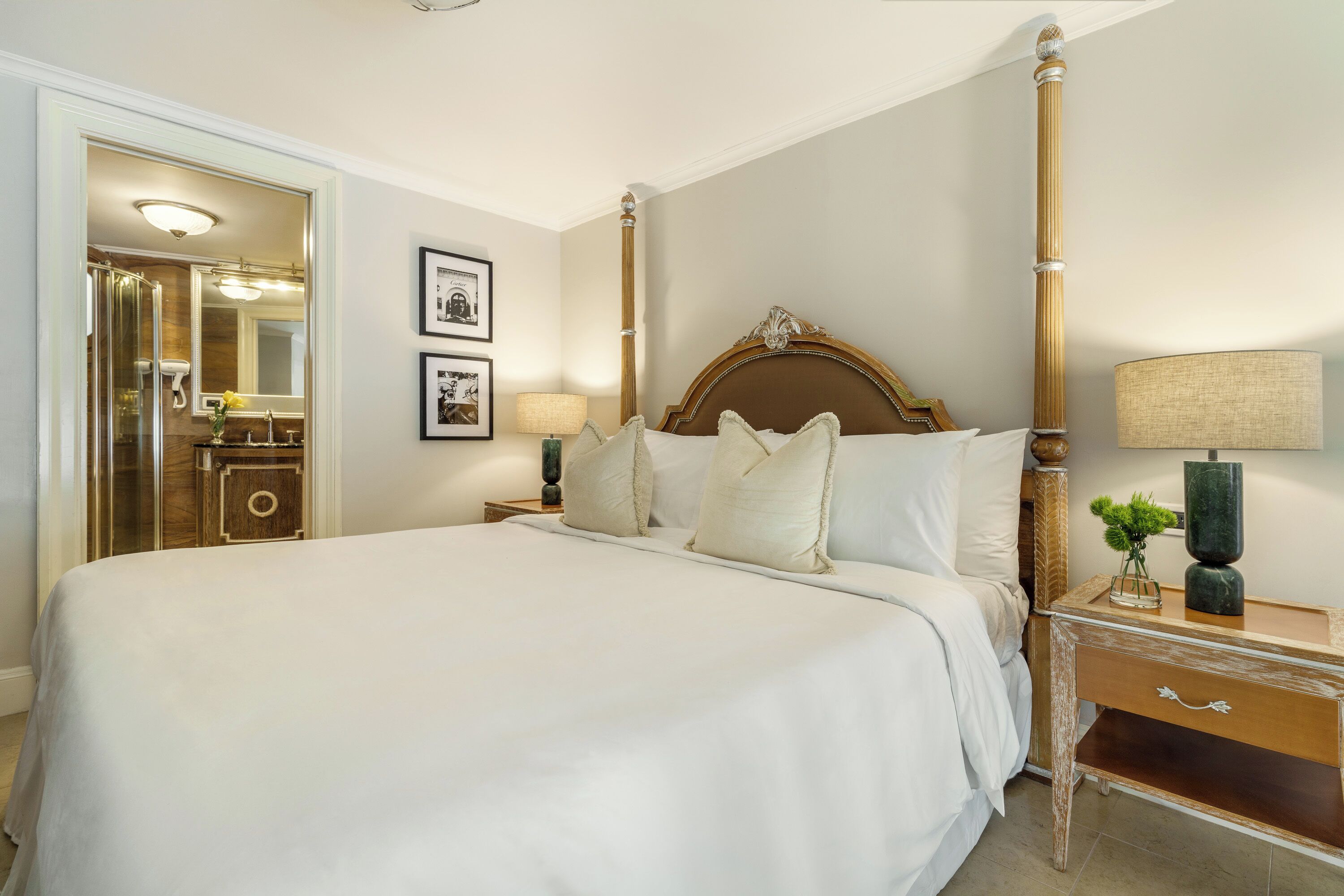 A large bed with a wooden headboard, a nightstand with a lamp, and a mirror.