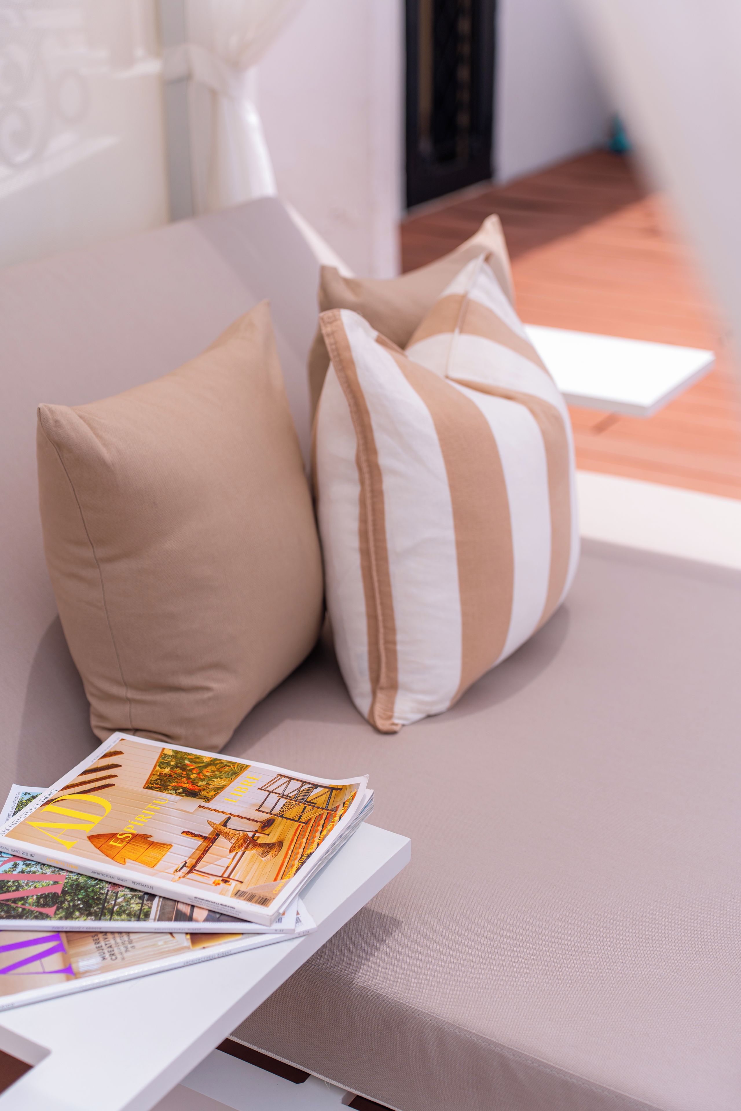 A bed with two pillows and a magazine on it.