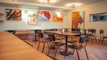 A restaurant interior with a long counter, booths, and a variety of seating options.