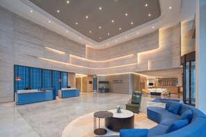 A spacious lobby with a reception desk, seating area, and a sign that reads "EXPECT THE UNEXPECTED". - Holiday Inn Express Chongqing Liangjiang Yufu by IHG (Chongqing)