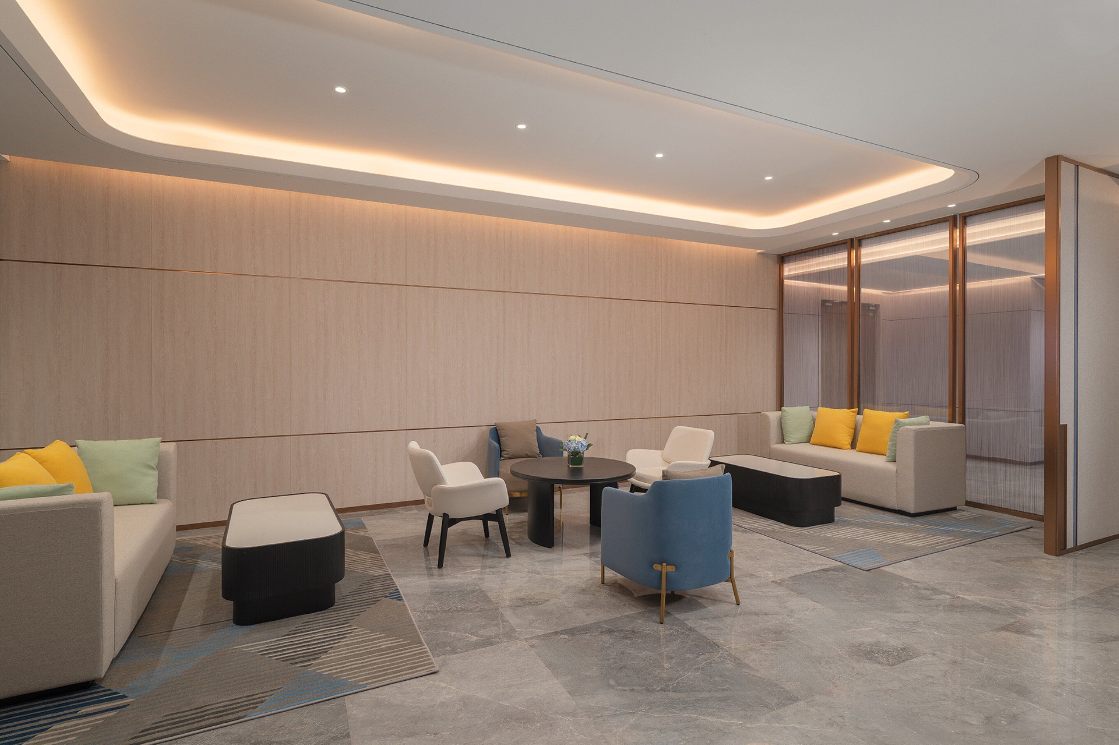 Un área de estar moderna con una mesa redonda, sofás y sillas, con una paleta de colores neutros y un diseño contemporáneo.