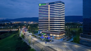 Ett högt hotell med en modern design, som har flera våningar och en framträdande entré.
