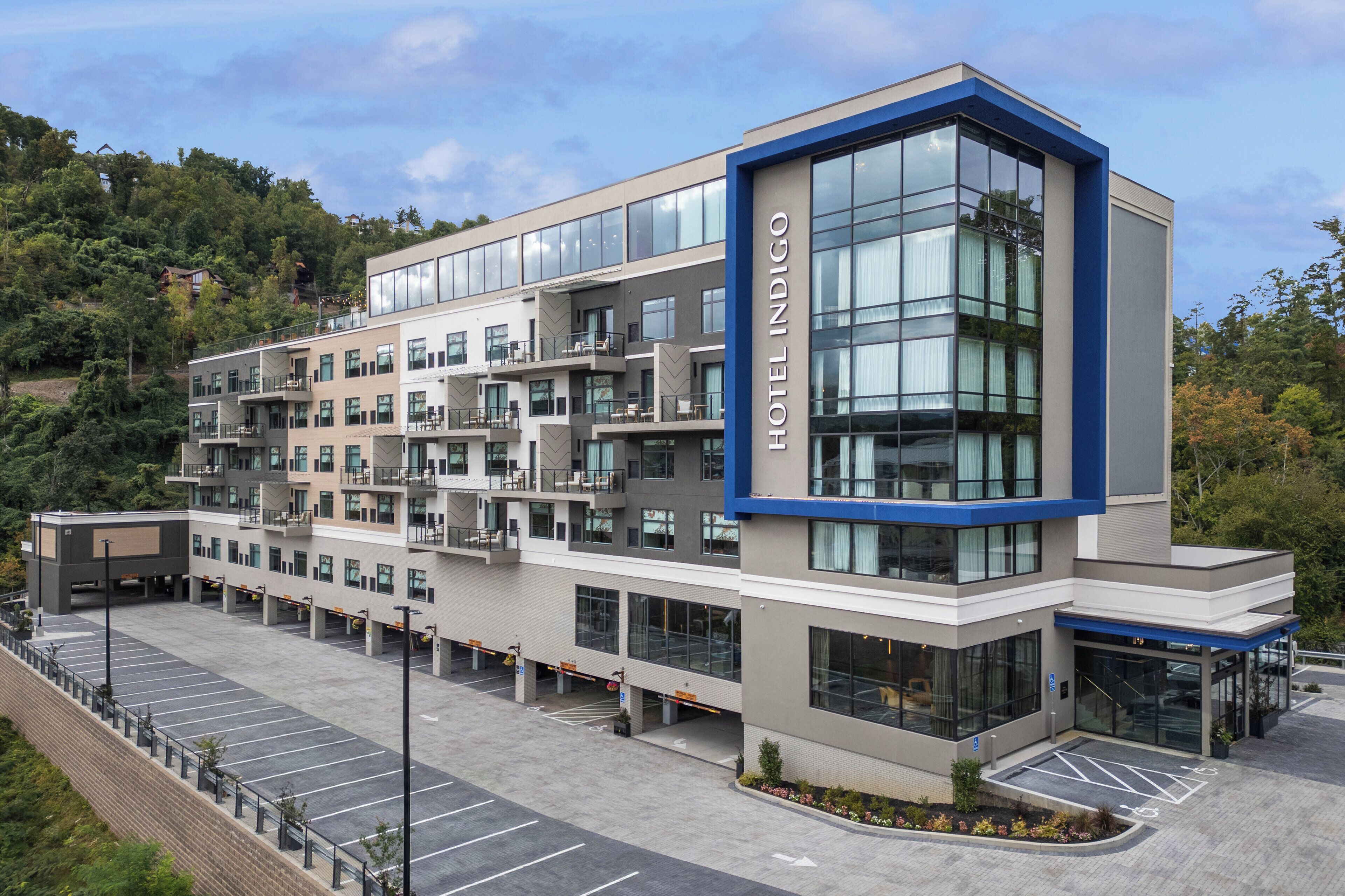 A multi-story hotel with a modern design, featuring a prominent glass facade and a blue accent wall.