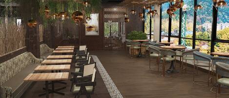 A restaurant with wooden tables and chairs, hanging spherical light fixtures, and large windows offering a view of greenery.