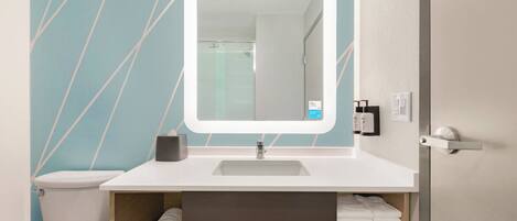 A bathroom with a white sink, a mirror, a towel rack, and a toilet.