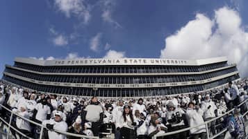 Uno stadio con la segnaletica 'The Pennsylvania State University', indicazioni sulla capacità di posti a sedere e una folla di spettatori.