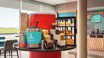 A breakfast station with Quaker Oatmeal, milk, and various food items.