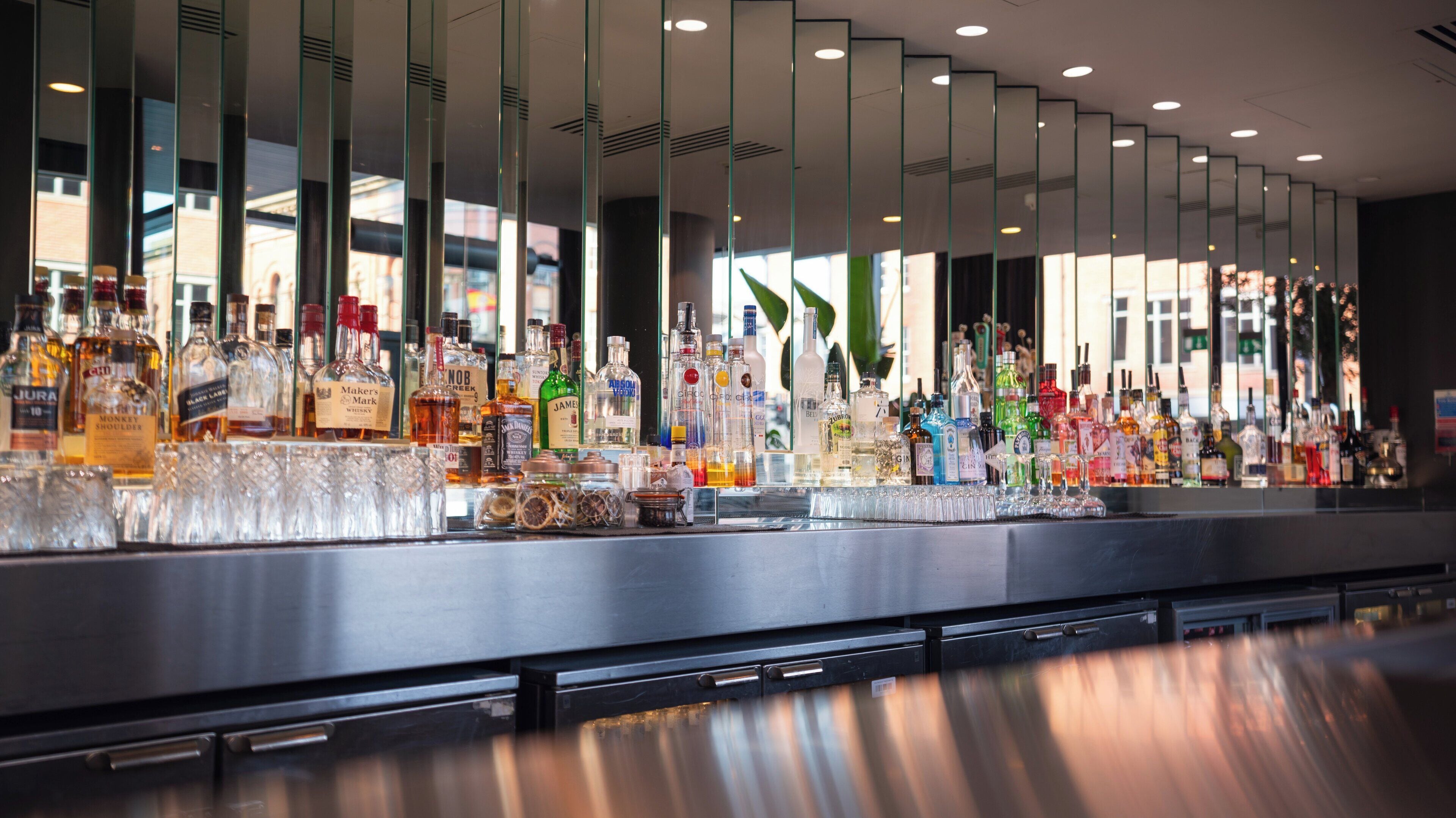 A bar with a variety of liquor bottles and glasses.