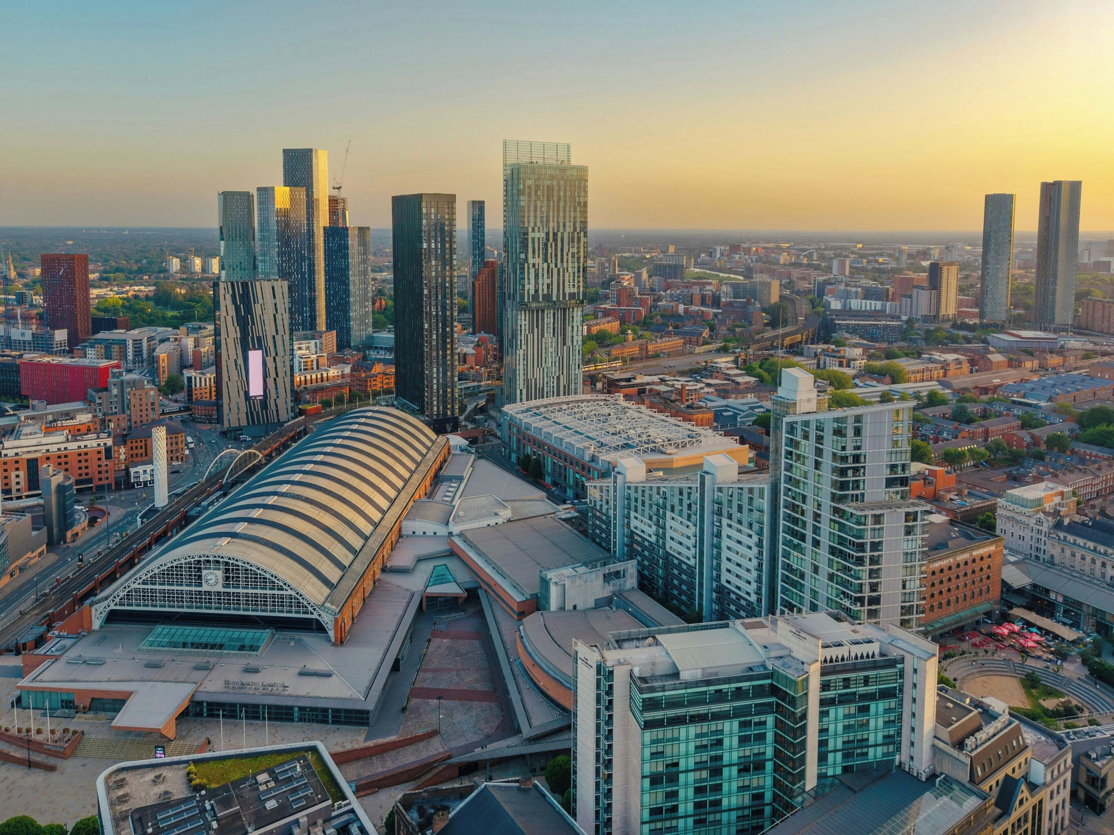 A modern cityscape with high-rise buildings, a distinctive stadium, and a mix of commercial and residential structures.