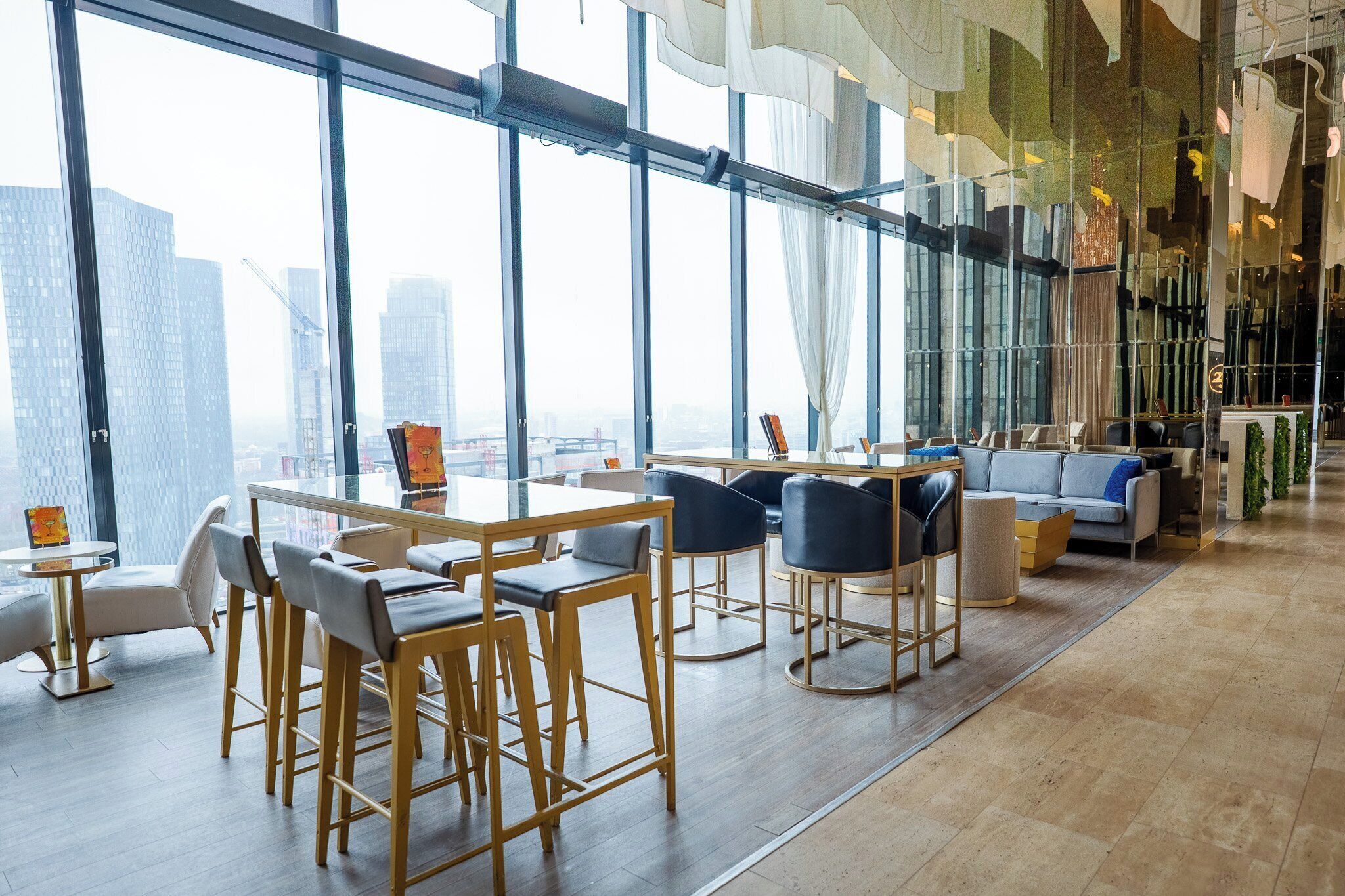 A modern interior with large windows, a bar area, and seating arrangements.