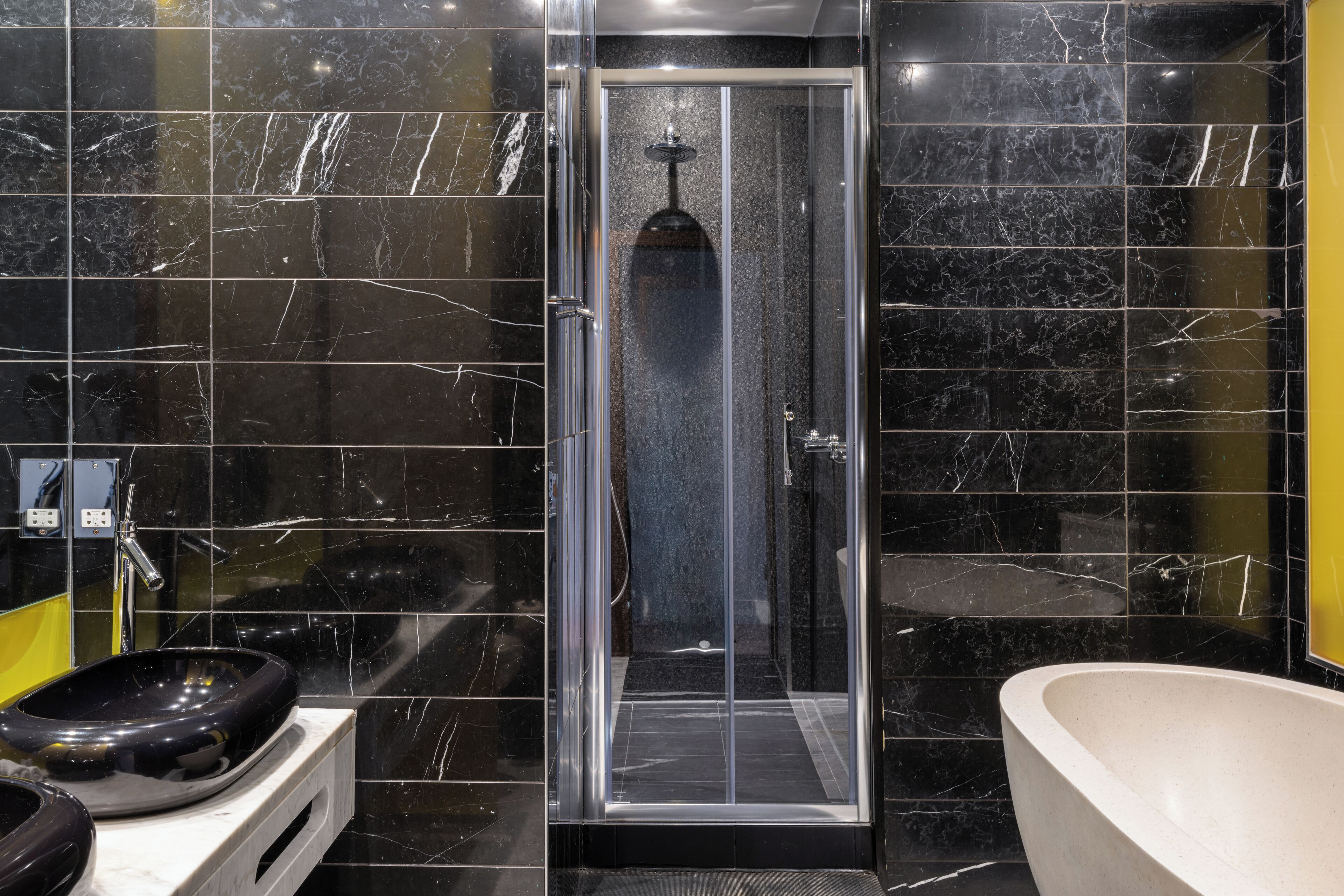 Une salle de bain avec une douche à parois de verre, un lavabo et une baignoire.