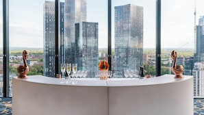 A reception desk with a view of tall buildings and a cityscape. - The Manchester Deansgate Hotel by IHG (Manchester)