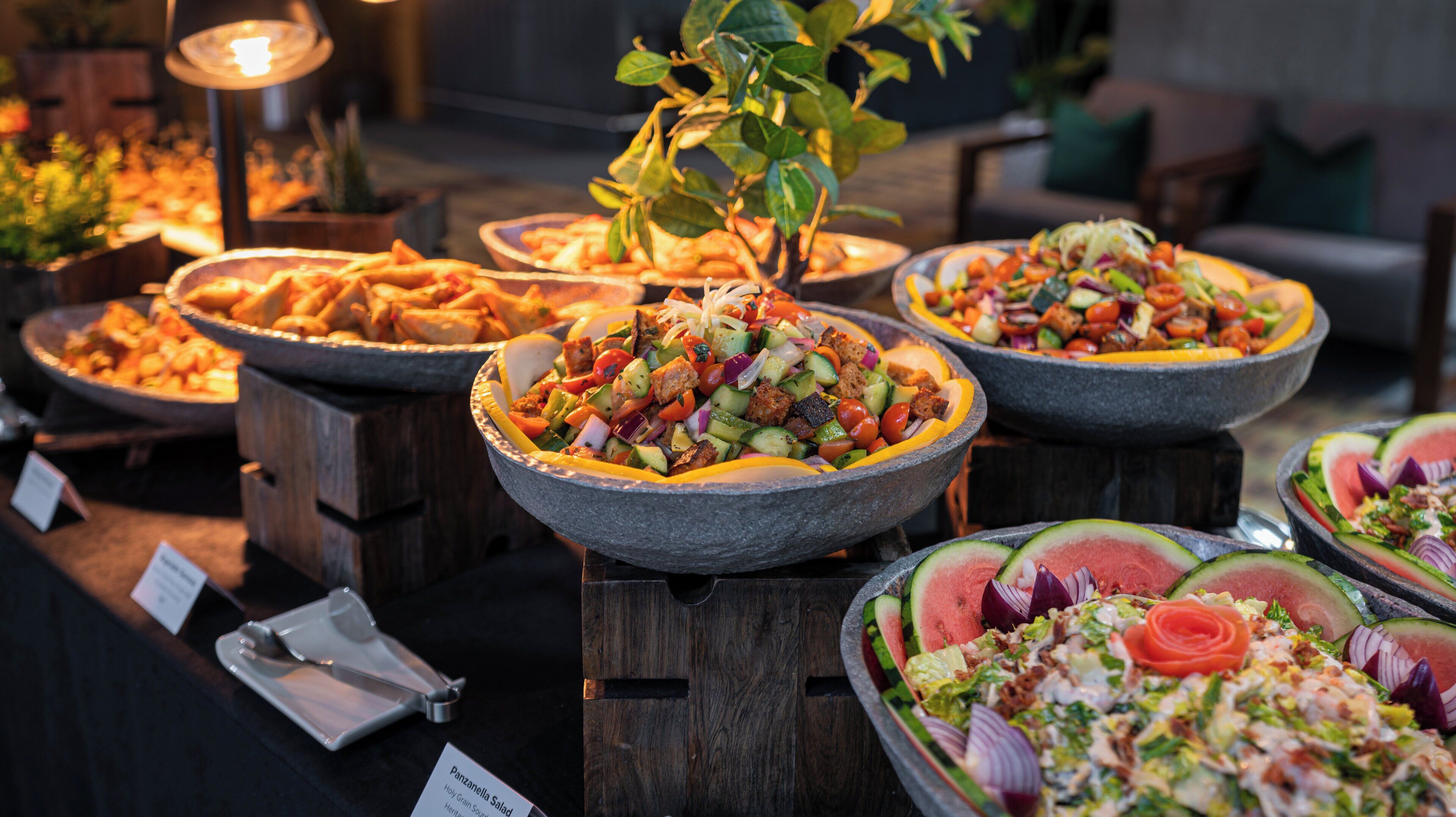 Een buffet met diverse gerechten, zoals salades, fruit en brood.