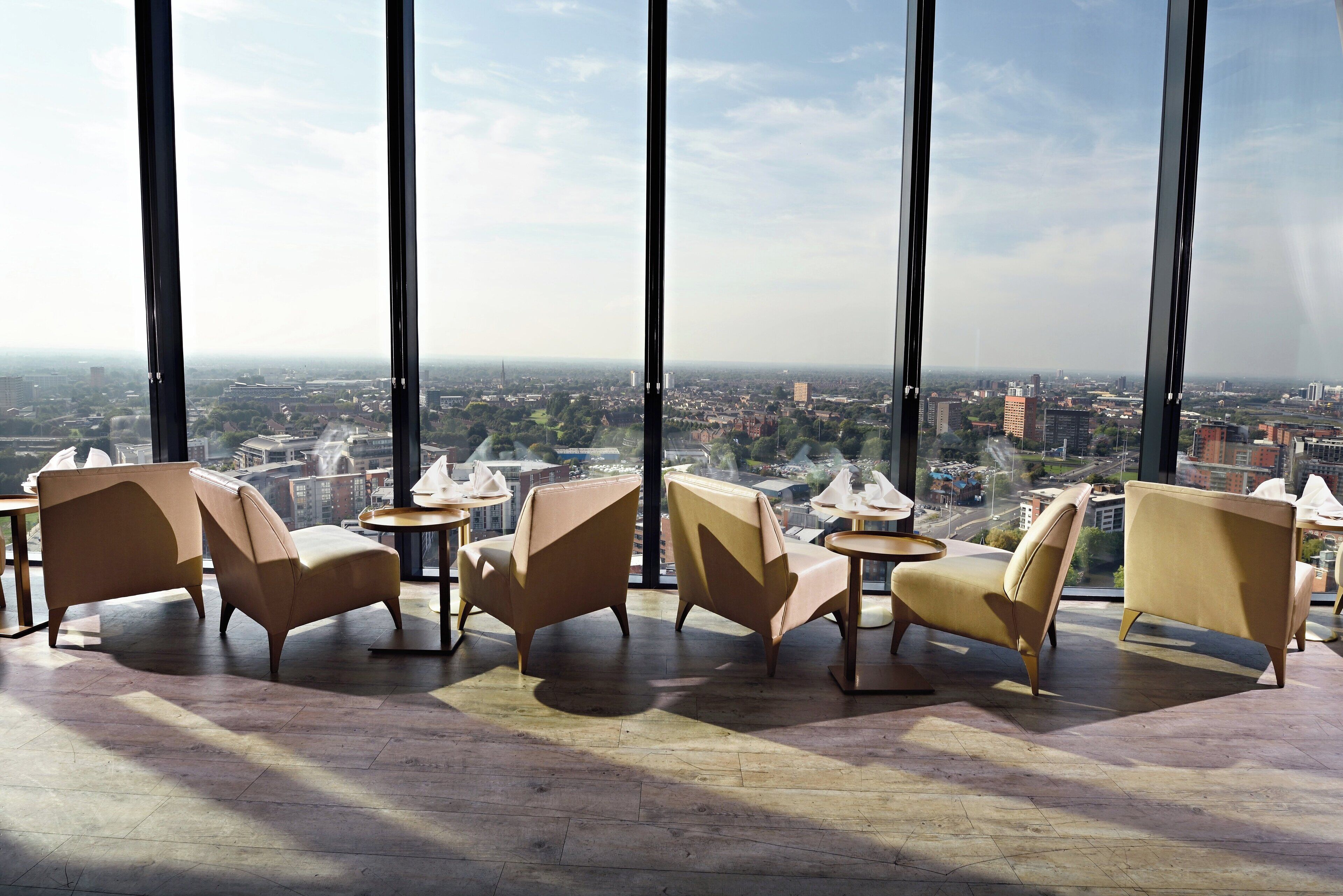 A high-rise hotel room with large windows offering a city view.