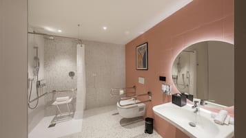 A modern bathroom with a shower, toilet, and sink.