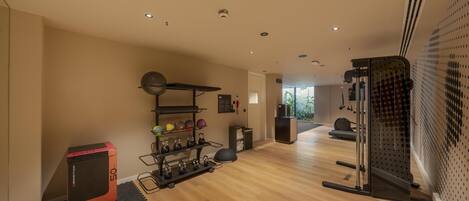 A modern home gym with a pull-up bar, kettlebells, and a weight bench.
