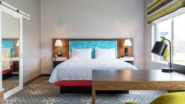 A hotel room with a bed, nightstands, a desk, and a window. - Hampton Inn & Suites Cedar City (Cedar City)