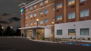 A hotel with a modern design, featuring a prominent logo on the building, a covered entrance, and a parking area with handicapped accessibility. - Tru By Hilton Middleburg Heights Cleveland Airport (Middleburg Heights)