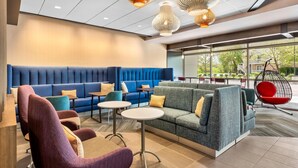 A modern lounge area with seating, tables, and hanging chairs. - Tru By Hilton Middleburg Heights Cleveland Airport (Middleburg Heights)