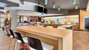 A modern breakfast area with a counter, seating, and a sign for 'TOP IT BREAKFAST'. - Tru By Hilton Middleburg Heights Cleveland Airport (Middleburg Heights)