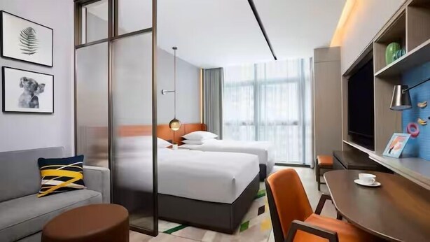 A hotel room with a bed, a sofa, a desk, and a TV. - Home2 Suites By Hilton Xi'An Bell Tower South Gate (Xi'an)