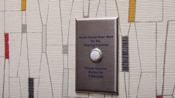 Timbre con alerta audiovisual para personas con discapacidad auditiva, con botón que requiere ser presionado durante 5 segundos.