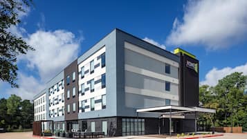 Un edificio moderno de hotel con techo plano, grandes ventanales y un cartel que indica que es un hotel Hilton.