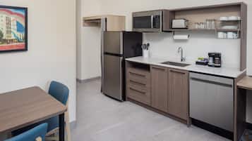 A compact kitchenette with a refrigerator, microwave, sink, and coffee maker.