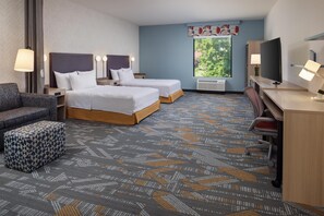 A hotel room with two beds, a desk, a television, and a window with a view of trees. - Home2 Suites By Hilton Tyler (Tyler)